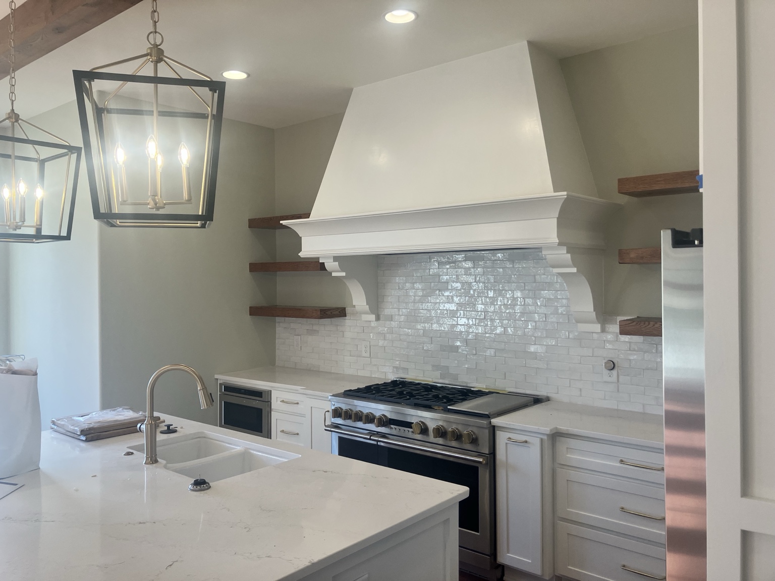 Custom kitchen hood, cabinetry, tile, and floating shelves