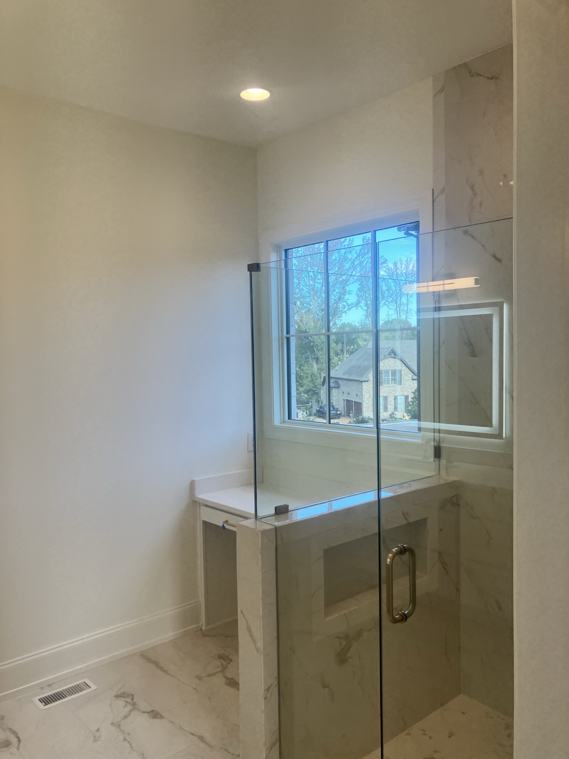 Custom glass shower with large-format marble tile